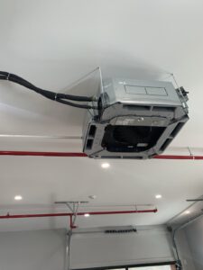 Electrical control unit mounted on finished mechanical room wall with piping