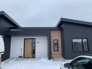 Modern home exterior with charcoal siding and natural wood accents