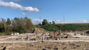 Construction site with foundation pilings, excavation, and equipment