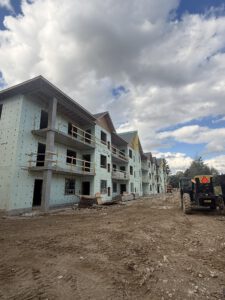Multi-story building facade under construction with protective wrap