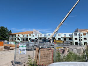 Construction site wide view with crane and security barriers