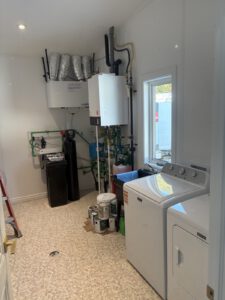 Mechanical room with boiler, green manifold piping, expansion tank