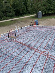 In-floor radiant heating system with red and black tubing