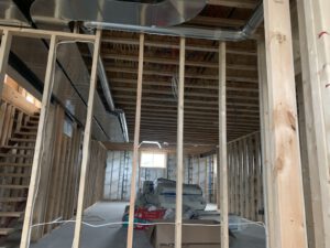 Interior frame with metal ductwork and insulation installation visible