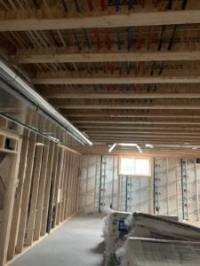 Framing cavity showing organized blue and red hydronic heating lines