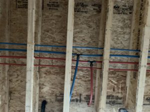 Wall cavity with embedded color-coded heating pipes in insulation