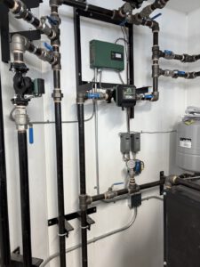 Close-up of radiant system manifold with blue and black piping and control actuators