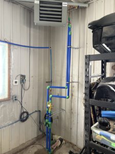 Overhead view of radiant floor heating tubing installation in open beam space