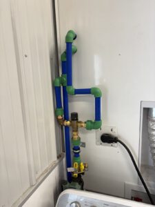 Detail of blue and green PEX tubing connections with smart control valve