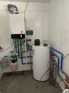 Radiant floor heating manifold with blue tubing and water heater