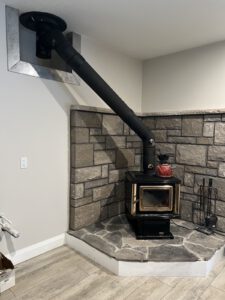 Finished wood stove in stone corner nook