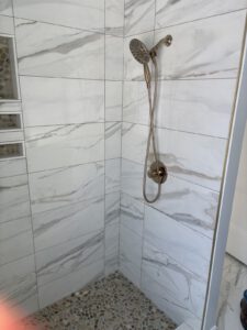 Finished marble shower with bronze fixture