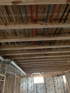 Red and blue PEX lines through ceiling joists