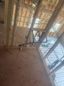 Ceiling view of wooden joists with black radiant heating lines installed