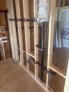 Under-floor view of joists with suspended radiant heating tubing