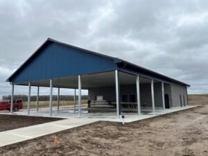 Finished pavilion with open sides, blue roof, white posts, brick siding