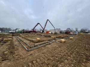 Concrete foundation work with pump truck delivering concrete for floor