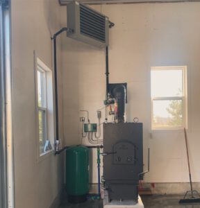 Indoor wood boiler with unit heater in outbuilding